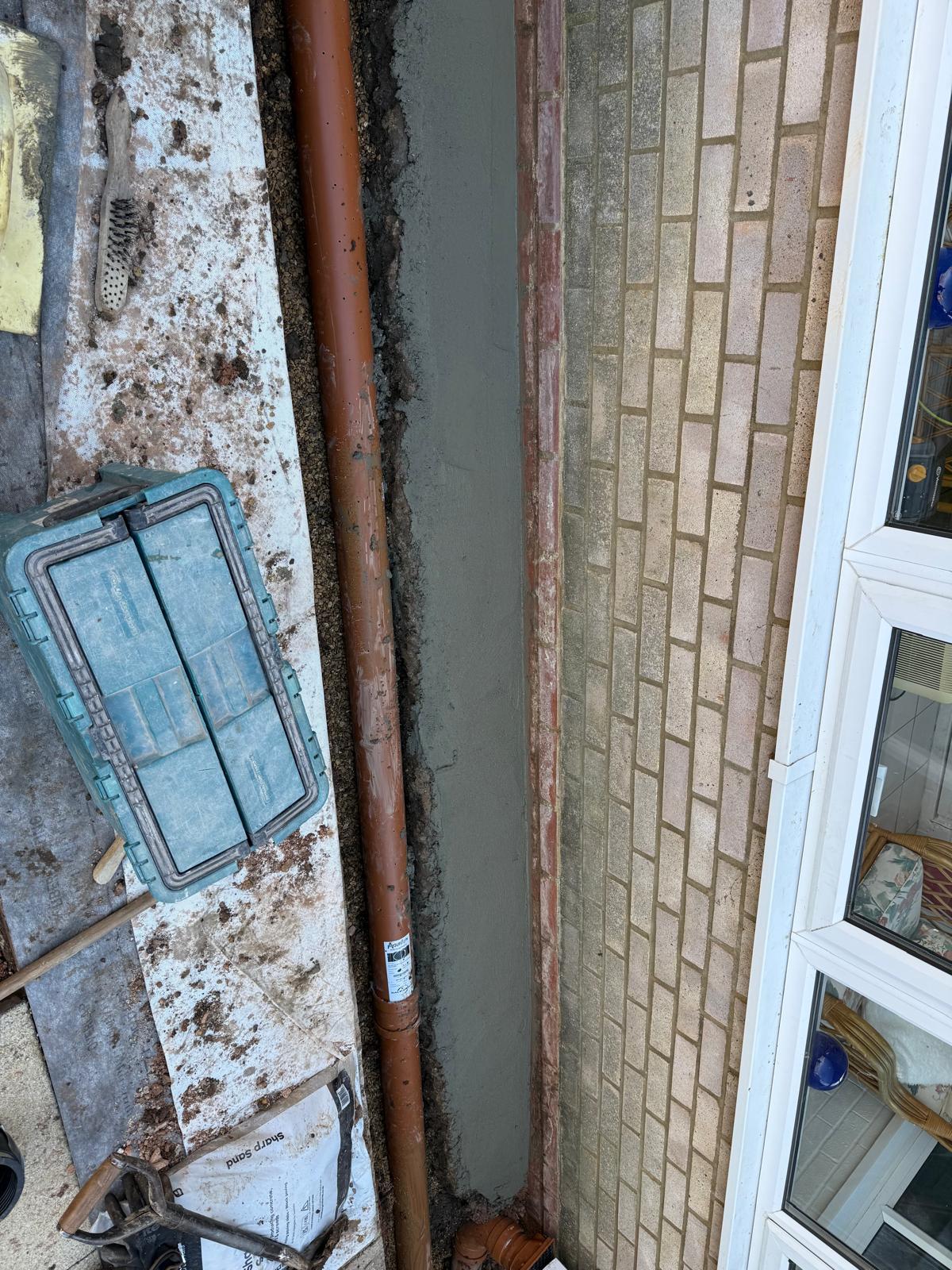 Drainage pipe rendered wall